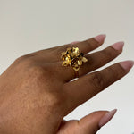 Load image into Gallery viewer, Gold flower ring shown on hand, with white neutral background, side view
